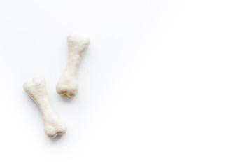 Food and toys for dogs. Chewing bones on white background top view space for text