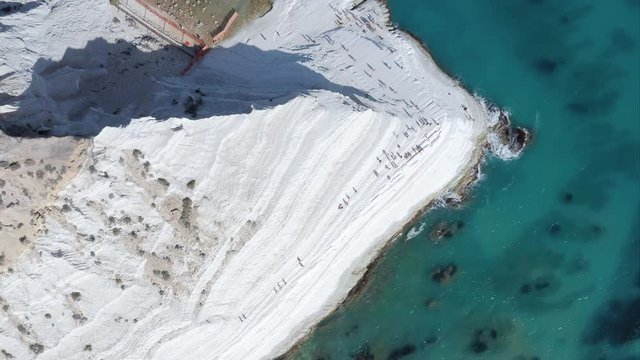 Scala dei Turchi (Stair of the Turks) - natural white marl cliff formation on the south coast of Sicily (Italy), with many people enjoying the sun and turquoise water of mediterranean sea.