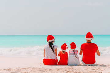 Happy family with two kids in Santa Hat on summer vacation