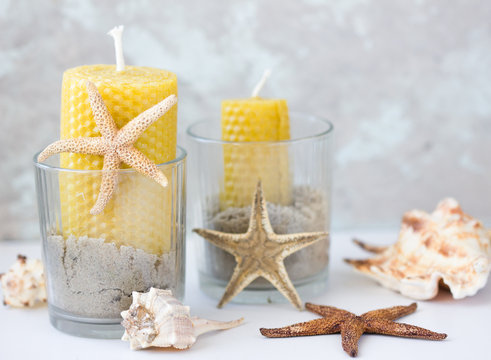 wax candles in jars with sea sand, sea shells. Marine style home accessories for beach themed interior decorating