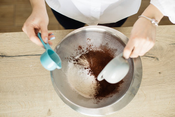 woman hands mixing dough on wooden table