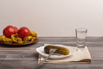 Traditional Russian snack - a glass of vodka and assorted pickles. Rustic style
