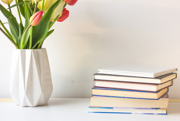 Stack of colorful books and flowers. Education background. 