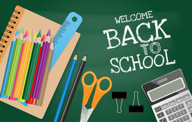 Back to school text on chalkboard with school supplies on green background