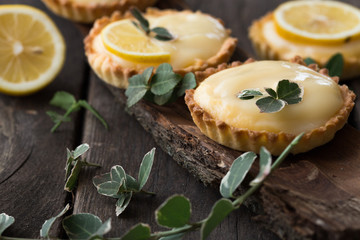 lemon custard tartalets with flowers on the bark of tree