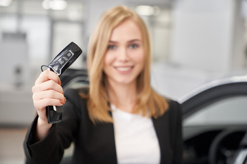 Fototapeta na wymiar Selective focus of car keys in hands of female car dealer