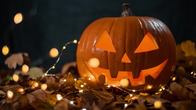 halloween carving pumpkin on a leafs. shining Jack-o'-lantern. Looping Cinemagraph. Still picture, moving light