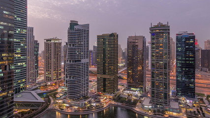 Residential and office buildings in Jumeirah lake towers district day to night timelapse in Dubai