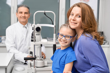 Obraz premium View from side of mother and child checking sight in clinic