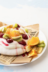 Meringue dessert Pavlova cake with fresh berries, mint on a stone background