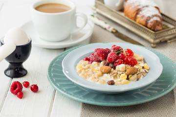 Breakfast Cereal, egg, juice, coffee. Table setting. Healthy tasty breakfast multigrain wholewheat healthy cereals with  raspberries, black currants and red currants.