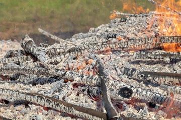 Burning wood in huge bonfire. Natural background of fire and ashes with copy space