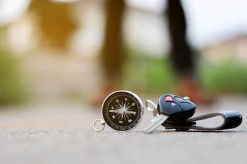A compass and car key on road background, journey of life concept