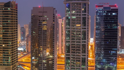 Obraz na płótnie Canvas Residential and office buildings in Jumeirah lake towers district night to day timelapse in Dubai