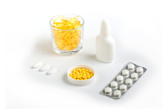 various medicines, yellow capsules, pills of various shapes and colors, spray in the nose on a white background