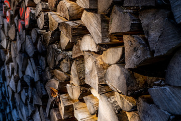 Close up of a stack of logs/wood from the end. Harvested firewood lies in the woodpil. background stack of wood