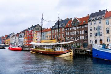 Fototapeta na wymiar Denmark. The most popular promenade in Copenhagen is Nyhavn. Bright multi-colored facades of old houses.