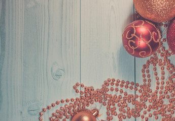 Christmas toys on wooden background. Gold beads with red balls. Christmas frame of toys on a wooden table.