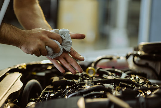 Close Up Of A Mechanic Cleaning His Hands After Servicing A Car In A Workshop