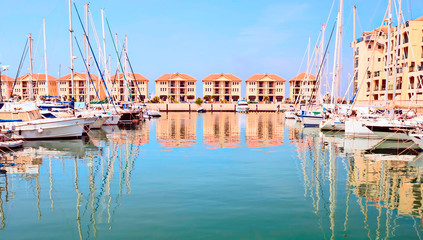 Boats in the port of Gibraltar, with the modern buildings in the background in a sunny day