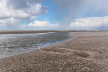 Wetterwechsel am Strand mit Wind, Regen und dunkle Wolken am Kijkduin Strand bei Den Haag, Holland, Niederlande