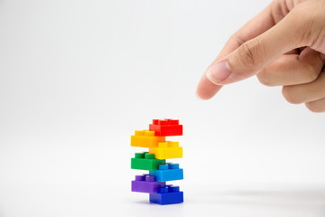 business concept hand and colorful brick blocks tower . strategy teamwork helping for success a...