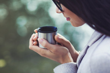 close-up portrait of a woman with a cup of tea in the autumn park