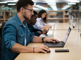 Multicultural group of students studying in a public library