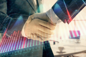 Multi exposure of financial graph on office background with two businessmen handshake. Concept of success in business