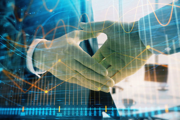 Multi exposure of financial graph on office background with two businessmen handshake. Concept of success in business