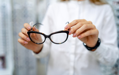 Eyeglasses closeup. Spectacles in woman's hands. Presenting glasses. Zoom in.