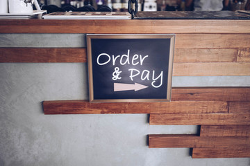 order and pay wooden chalkboard tag on counter bar in cafe or retail shop