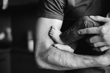 babies legs in fathers hands