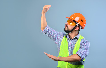 Building process control. Worker builder with helmet gesticulates with hands and supervises the...