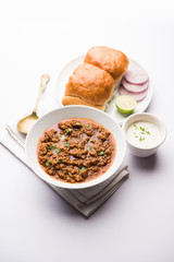 Kheema / keema Pav or Khima Paav is a spicy curry dish made up of minced chicken or lamb cooked with onion, tomatoes, served with buns. selective focus