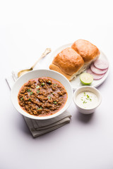 Kheema / keema Pav or Khima Paav is a spicy curry dish made up of minced chicken or lamb cooked with onion, tomatoes, served with buns. selective focus