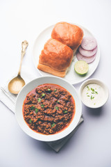 Kheema / keema Pav or Khima Paav is a spicy curry dish made up of minced chicken or lamb cooked with onion, tomatoes, served with buns. selective focus