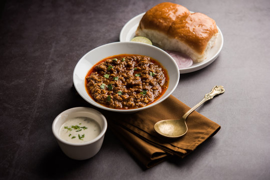 Kheema / keema Pav or Khima Paav is a spicy curry dish made up of minced chicken or lamb cooked with onion, tomatoes, served with buns. selective focus