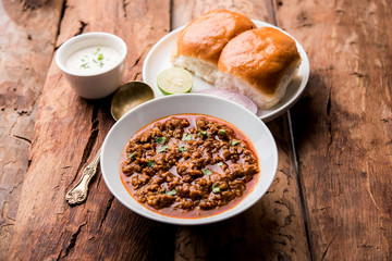 Kheema / keema Pav or Khima Paav is a spicy curry dish made up of minced chicken or lamb cooked with onion, tomatoes, served with buns. selective focus