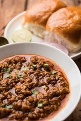 Kheema / keema Pav or Khima Paav is a spicy curry dish made up of minced chicken or lamb cooked with onion, tomatoes, served with buns. selective focus