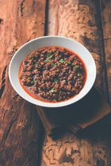 Kheema / keema Pav or Khima Paav is a spicy curry dish made up of minced chicken or lamb cooked with onion, tomatoes, served with buns. selective focus