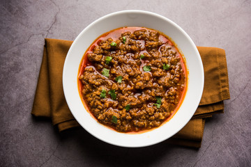 Kheema / keema Pav or Khima Paav is a spicy curry dish made up of minced chicken or lamb cooked with onion, tomatoes, served with buns. selective focus