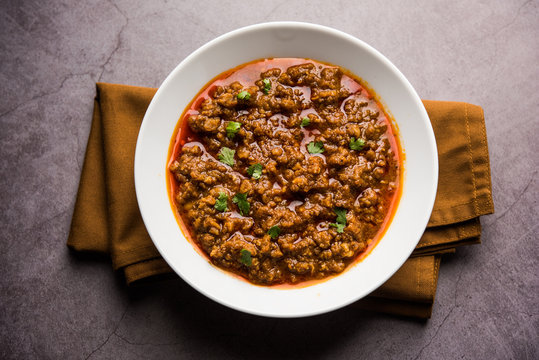 Kheema / keema Pav or Khima Paav is a spicy curry dish made up of minced chicken or lamb cooked with onion, tomatoes, served with buns. selective focus