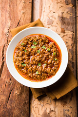 Kheema / keema Pav or Khima Paav is a spicy curry dish made up of minced chicken or lamb cooked with onion, tomatoes, served with buns. selective focus