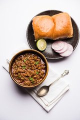 Kheema / keema Pav or Khima Paav is a spicy curry dish made up of minced chicken or lamb cooked with onion, tomatoes, served with buns. selective focus