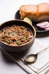 Kheema / keema Pav or Khima Paav is a spicy curry dish made up of minced chicken or lamb cooked with onion, tomatoes, served with buns. selective focus