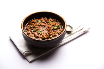 Kheema / keema Pav or Khima Paav is a spicy curry dish made up of minced chicken or lamb cooked with onion, tomatoes, served with buns. selective focus