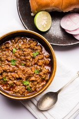 Kheema / keema Pav or Khima Paav is a spicy curry dish made up of minced chicken or lamb cooked with onion, tomatoes, served with buns. selective focus
