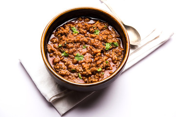 Kheema / keema Pav or Khima Paav is a spicy curry dish made up of minced chicken or lamb cooked with onion, tomatoes, served with buns. selective focus
