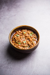 Kheema / keema Pav or Khima Paav is a spicy curry dish made up of minced chicken or lamb cooked with onion, tomatoes, served with buns. selective focus